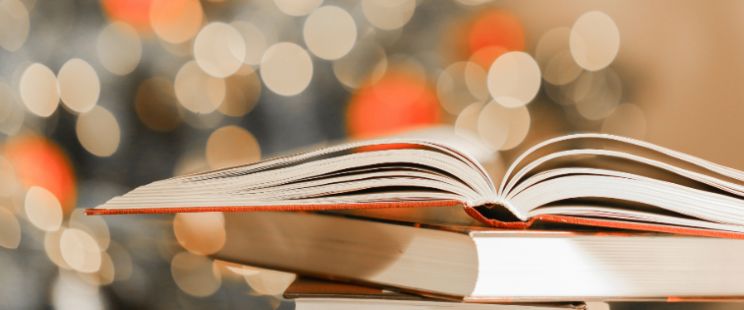 Pile de livres avec un décor lumineux pour les fêtes de fin d'année